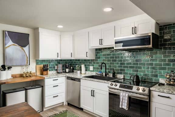 Bright and well-equipped, the kitchen offers full-size appliances, plenty of prep space, and a beautiful tiled backsplash that ties the look together.