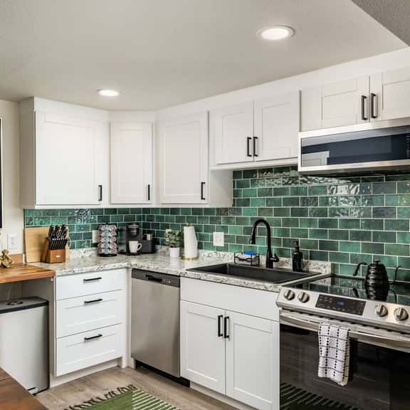 Bright and well-equipped, the kitchen offers full-size appliances, plenty of prep space, and a beautiful tiled backsplash that ties the look together.