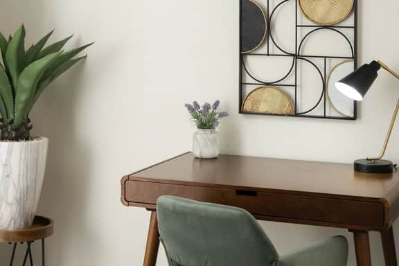 A peaceful corner to catch up on work or jot down travel plans, complete with a modern desk, task lamp, and minimalist wall décor.